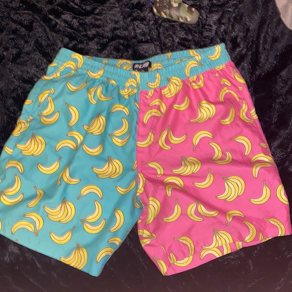 Swimming trunks teal and pink yellow banana pattern and there a small